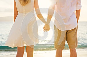 Young couple in love on the beach sunset