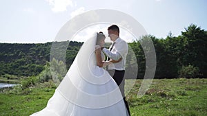 Young couple in love bride and groom, wedding day near a river. Steadycam shoot