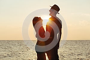 Young couple in love enjoying sunset on the beach