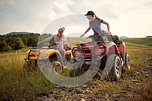 A young couple in love enjoys riding quads in the nature. Riding, relationship, nature, activity photo