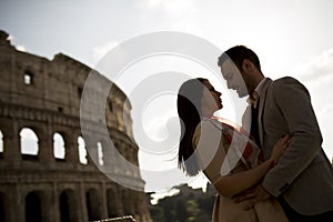 Young couple in love in front of the Colosseum in Rome