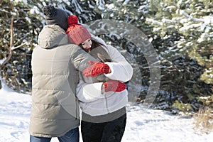 Young couple in love has fun in winter outdoors. Guy embrance his girlfriend. Winter holidays