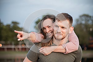 Young couple in love having fun, the man carries the woman on his back