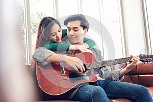 Young Couple Love Having Fun While Sing a Song and Playing Guitar in Living Room Together, Portrait of Couple are Relaxing at