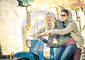 Young couple in love having fun on a vintage scooter moped