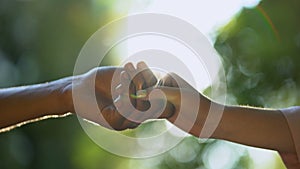 Young couple in love holding hands against park background, trustful relations