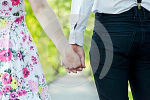 Young couple in love holding hands in summer park. Dating