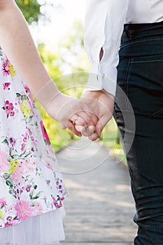 Young couple in love holding hands in summer park. Dating