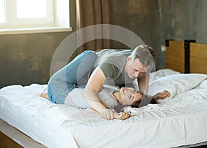 young couple in love jokingly fight on the bed, hugging and having fun