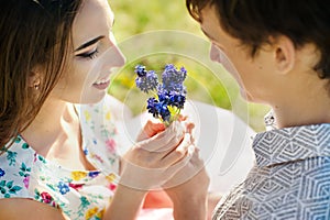 Young couple in love kissing and hugging at blue flowers. Close up