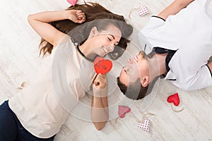 Young couple in love lying on floor, top view