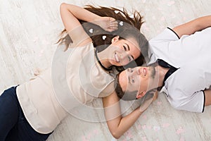 Young couple in love lying on floor, top view