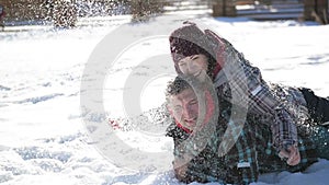 Young Couple in Love is Lying on the Snow and Having Fun During Their Winter Vacation. Funny Woman is Throwing Snow in