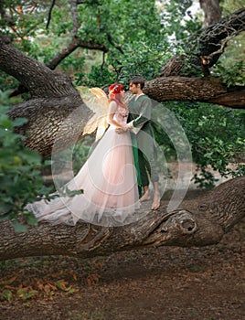 Young couple in love. A man and a woman are hugging on a huge tree. Themed creative wedding bright fantasy photography