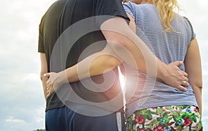 Young couple in love men and women hugging against the sky, Sunny summer day in the countryside in nature