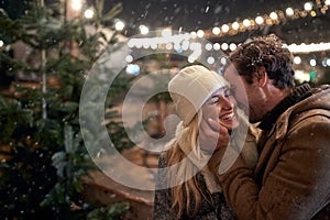 A young couple in love and moments of closeness on a snowy weather in the city. Christmas tree, love, relationship, Xmas, snow