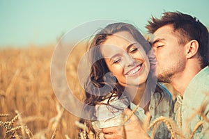 Young couple in love outdoor.Couple hugging.Young beautiful couple in love staying and kissing on the field on sunset.