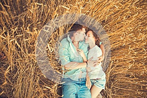 Young couple in love outdoor.Couple hugging.Young beautiful couple in love staying and kissing on the field on sunset.