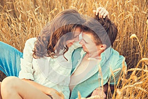 Young couple in love outdoor.d.Couple hugging.Young beautiful couple in love staying and kissing on the field on sunset.