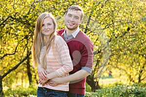 Young couple in love outdoor. Happy people walking in the woods hugging each other, having a spring mood and enjoying life