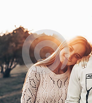 Young couple in love outdoor. They are smiling and looking at each other. evening sunlight, hugs and kisses, vintage style