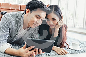 Young Couple Love Relax Enjoyment While Online Shopping on Electronic Tablet in Living Room, Portrait of Asian Couple Relaxing on