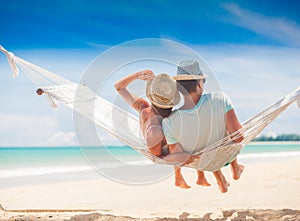 Young couple in love relaxing in a hammock by the beach