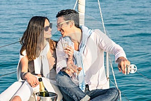 Young couple in love on sail boat with champagne flute