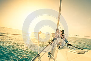 Young couple in love on sail boat with champagne at sunset