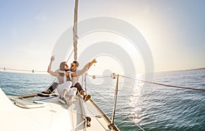 Young couple in love on sail boat with champagne at sunset - Hap