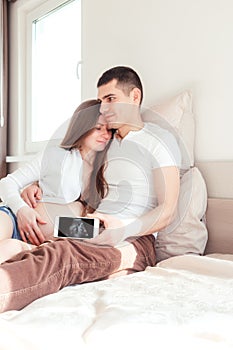 Young couple in love showing an ultrasound picture