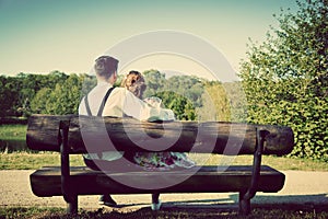 Young couple in love sitting on a bench in park. Vintage