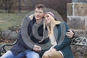 Young couple in love sitting together on the bench