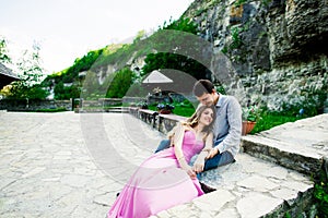 Young couple in love sitting together on a bench in summer park. Happy future, marriage concepts. Vintage