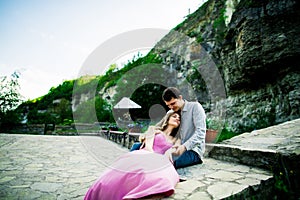 Young couple in love sitting together on a bench in summer park. Happy future, marriage concepts. Vintage