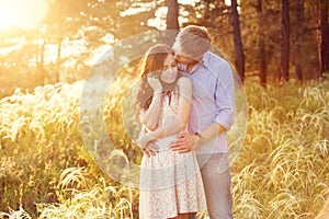 Young couple in love at sunset at the field