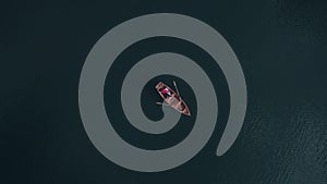 Young couple in love together in romantic boat trip. Drone shot from the top. Lovers paddle on beautiful lake. Travel