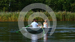 Young couple love walk in boat on lake