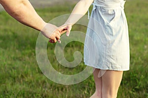 Young couple in love walking in the autumn park holding hands looking in the sunset