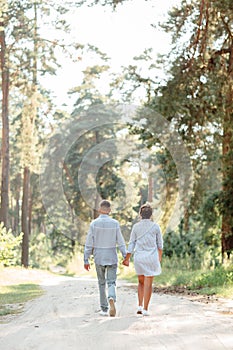 Young couple in love walking and enjoying the beautiful summer nature. woman and man, wearing in denim outfit are having date