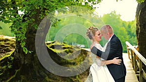 Young couple in love walking on suspended wooden bridge in the forest