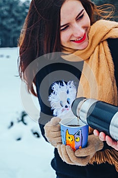 Young couple in love in wood. Man pours tea from a thermos. Close-up