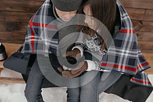 Young couple in love in the woods basking under a blanket. They drink tea from a thermos.Close-up.