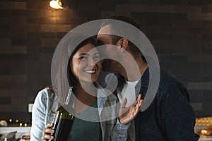 Young couple of lovers celebrating at home drinking wine