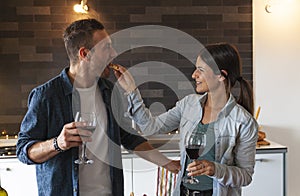 Young couple of lovers celebrating at home drinking wine