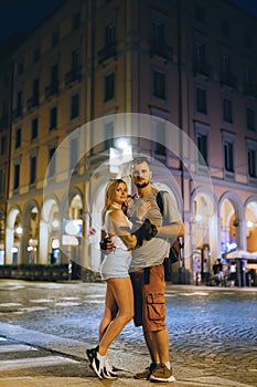A young couple of lovers walking the night streets of old italy. Summer evening. Tourism and vacation. Relationships and love.