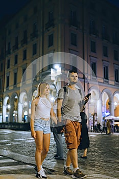 A young couple of lovers walking the night streets of old italy. Summer evening. Tourism and vacation. Relationships and love.