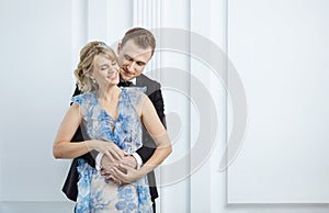 Young couple in luxury fashionable clothes hugging and laughing