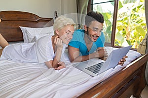 Young Couple Lying In Bed, Happy Smile Hispanic Man And Woman Using Laptop Computer