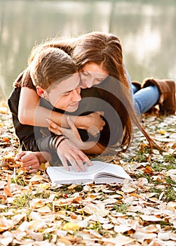 Young couple lying down reading